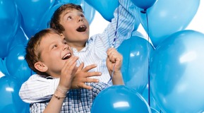 Two children with helium filled balloons